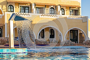 Hydromassage water with gentle splashes at spa resort. Waterfall flow in spa swimming pool. Hydrotherapy, health and
