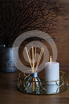 hygge and aromatherapy concept - candles and aroma diffuser on table at home