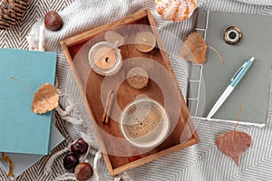 Hygge. Autumn still life with coffee, candles, fall leaves, a journal, and books