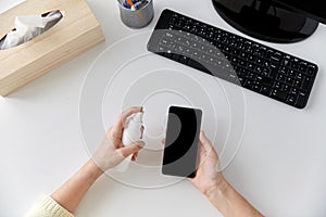 Close up of woman cleaning smartphone photo