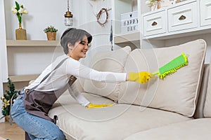 Hygiene and cleanliness in the living room. A Cleaning lady with gloves wipes dust from furniture with a cloth