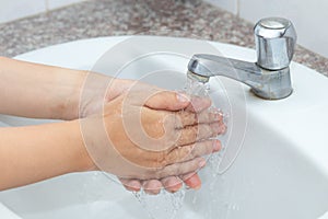 Hygiene concept cleaning hand and washing hands. A man washes his hands with soap and water in the basin