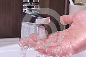Hygiene concept, a man washing hands in the bathroom close-up