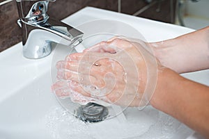 Hygiene concept. Washing hands with soap under the faucet with water