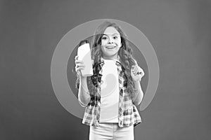 Hygiene habits for kids. Happy little girl holding gel or shampoo bottle for personal hygiene on red background. Small