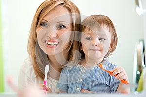 Hygiene. Happy mother and child brushing teeth