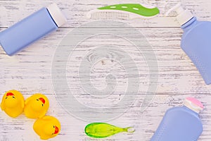 Hygiene items for the child. Bath accessories with yellow rubber duck on light grey wooden background top view copy