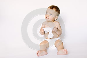 Hygiene - little baby girl get wet wipes, and wipes her face  on white background. Cleaning wipe, pure, clean