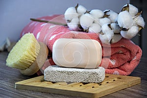 Hygiene supplies for bath and spa treatments on a wooden background. Cotton, natural body brush, towel, soap and pumice