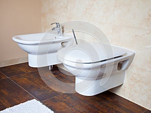 Hygiene. White porcelain bidet and toilet. Interior of bathroom.