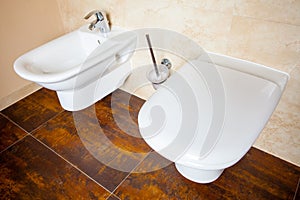 Hygiene. White porcelain bidet and toilet. Interior of bathroom.