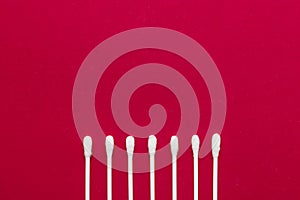 Hygienic, cotton buds on a red background. The concept of hygiene, cleanliness