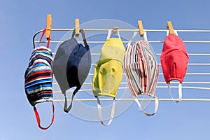 Hygienic mask hanging on the rack outdoor after being washed for cleanness and hygiene during Covid-19 virus outbreak. Drying mask photo