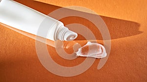 Hygienic moisturizing lip balm in a tube on a orange background.