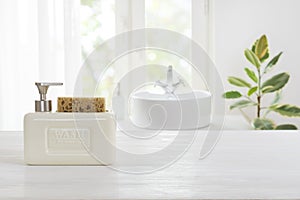 Hygienic soap dispenser on table against defocused bathroom sink background