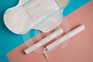 Hygienic tampons and pad on a blue and pink background. copy space