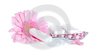 Hygienic tampons, pills and flower on white background