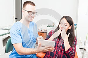 Hygienist with patient showing something on tablet photo