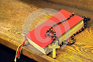 Hymnal book and wooden rosary bead
