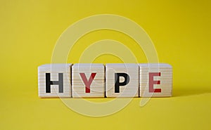 Hype symbol. Concept word Hype on wooden cubes. Beautiful yellow background. Business and Hype concept. Copy space