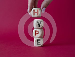 Hype symbol. Concept word Hype on wooden cubes. Businessman hand. Beautiful red background. Business and Hype concept. Copy space