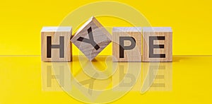 HYPE - wooden blocks with letters, hype concept, front view on yellow background