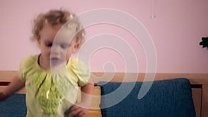 Hyperactive child girl jumping on bed in bedroom