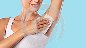 Closeup of unrecognizable young woman wiping armpit photo