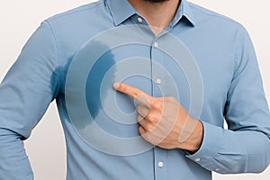 man pointing to sweat stain on shirt hyperhidrosis excessive sweating breathability sweat resistance fabric wet area photo