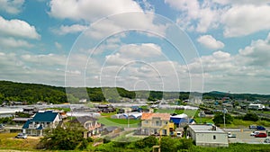 Hyperlapse: Clouds move over houses and busy road in green suburban country