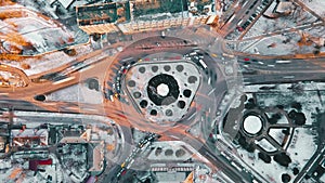 Hyperlapse of a roundabout intersection, drone view. Roads with moving cars, bare trees, snow on the ground. Chisinau, Moldova