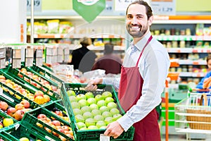 Hypermarket clerk filling up storage racks