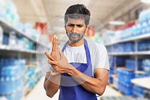 Hypermarket employee touching sprained wrist
