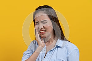 Hypersensitive teeth and gum health. young woman touching her cheek and have a dental problem