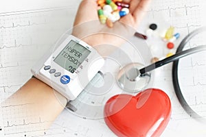 Hypertensive heart disease concept with womanâ€™s arm measuring blood pressure