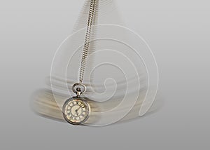 Hypnosis session. Vintage pocket watch with chain swinging on light background, motion effect