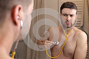 Hypochondriac man listening to his own heartbeat photo