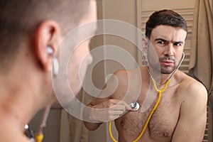 Hypochondriac man listening to his own heartbeat photo