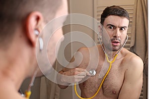 Hypochondriac man listening to his own heartbeat photo