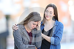 Hypocrite bad woman comforting her sad friend photo