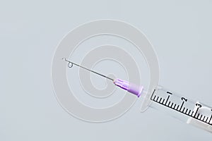Hypodermic needle ejecting clear liquid - isolated syringe