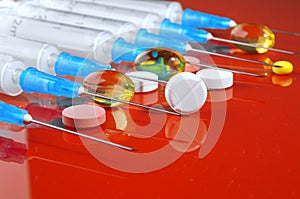 Hypodermic syringe. Syringes with blue needles on a red background. Medical Injectors.