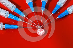 Hypodermic syringe. Syringes with blue needles on a red background. Medical Injectors.