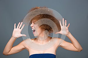 Hysterical excited curly woman sreaming and shaking her head