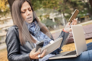 Hysterical girl with too many screens, mobils, tablets and laptops