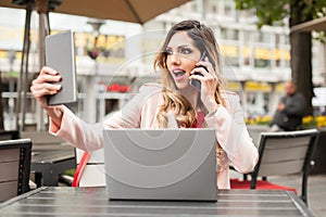 Hysterical woman with too many screens, mobils, tablets and laptops