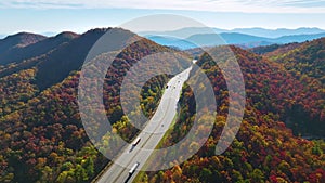 I-40 freeway in North Carolina leading to Asheville through Appalachian mountains in golden fall with fast moving trucks