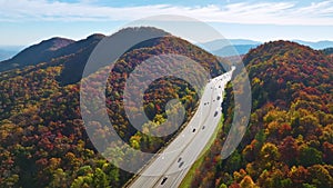 I-40 freeway road leading to Asheville in North Carolina over Appalachian mountain pass with yellow fall forest and fast