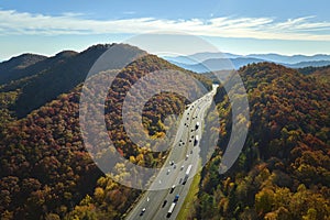 I-40 freeway road leading to Asheville in North Carolina over Appalachian mountain pass with yellow fall forest and fast