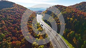 I-40 freeway road leading to Asheville in North Carolina thru Appalachian mountains with yellow fall forest and fast